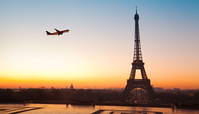 Eiffel tower at sunrise and airplane in the blue sky