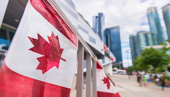 Canada plastic flag with blurred urban background in Toronto