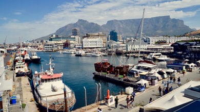 Cape Town the capital city of South Africa, busy fishing harbour beside the Victoria and Albert Waterfront. Tourists wander along boardwalk and busy fish restaurants. Cape Town, Western Cape, South Africa. November 2018