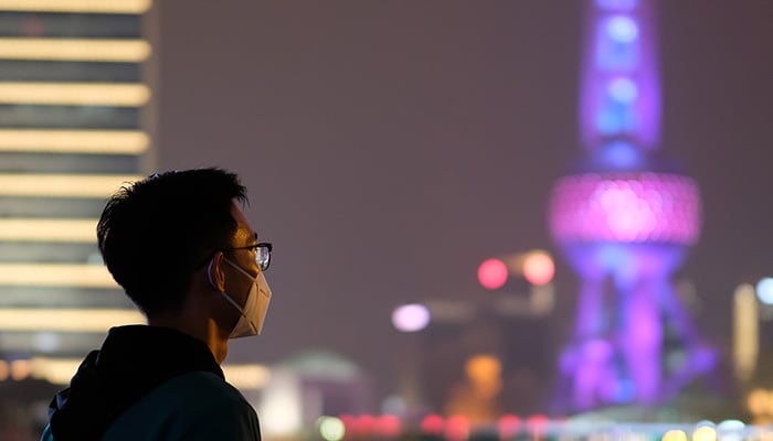 Shanghai/China-Jan.2020: New type coronavirus 2019-nCoV pneumonia in Wuhan has been spreading into many cities in China. Young man wearing surgical mask looking at Oriental Pearl TV Tower