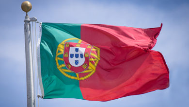 A Portuguese flag flies in a stiff breeze.