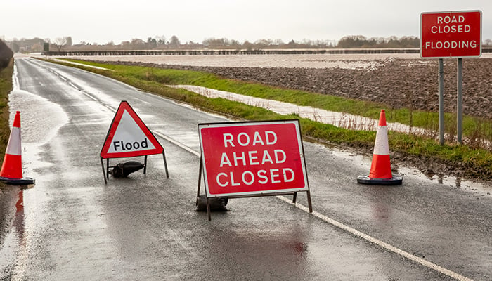 Road ahead closed and flood warning signs on the road to Cawood Bridge in Selby, North Yorkshire during Storm Christoph. The River Ouse has burst its banks and water is flooding into surrounding field Cawood, Selby, UK