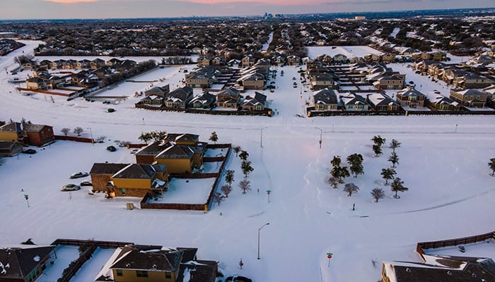 snow covered landscape above Austin Texas after winter storm Uri during morning sunrise over suburb homes