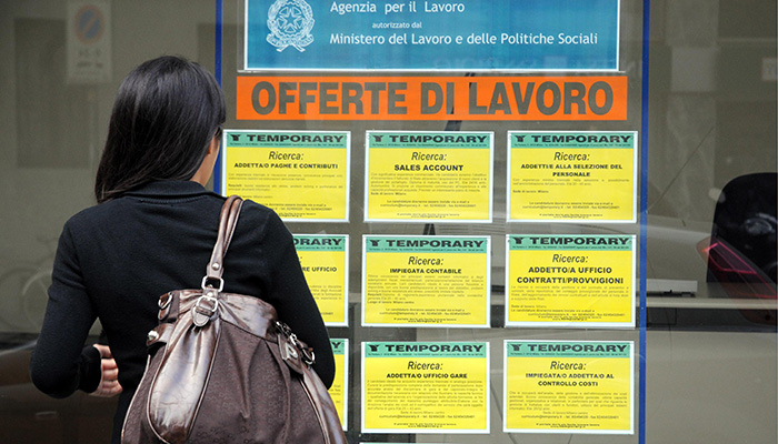 Italy - Milan April4,2018 - job offers - girl in front of the window of an agency for temporary work, unemployment and economic crisis.