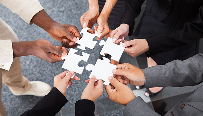 Close-up Photo Of Businesspeople Holding Jigsaw Puzzle