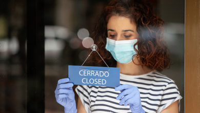 Depressed shop assistant closing her retail business to the public during the pandemic quarantine covid 19 in Spain. Financial crisis and coronavirus concept.