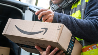 Berlin, Germany - January 27, 2020: Cropped shot of an Amazon Prime delivery agent scanning barcodes on boxes during his work shift. Amazon is an American electronic online commerce company