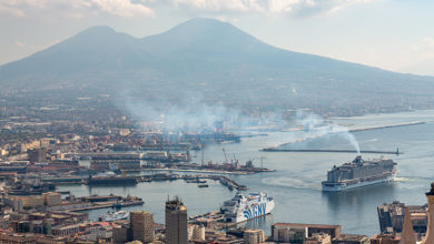 Naples, Italy, October 2021: View of Naples commercial port with cruise ship diesel exhaust fumes floating over city center.