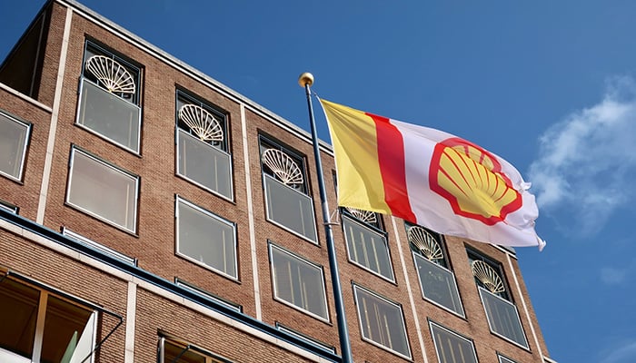 THE HAGUE - AUGUST 19, 2019: ROYAL DUTCH SHELL company flag and logo at headquarters building