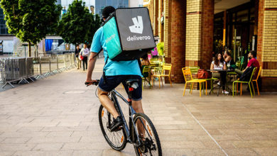 Coventry, UK - July 4, 2018: Deliveroo driver is riding in Coventry City Centre, busiest time of the day evening for Delivery.