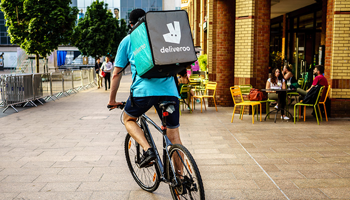 Coventry, UK - July 4, 2018: Deliveroo driver is riding in Coventry City Centre, busiest time of the day evening for Delivery.