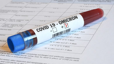 Blood tube for test detection of virus Covid-19 Omicron Variant with positive result on papers document.