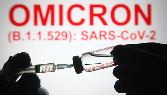 In this photo illustration of a new COVID-19 variant a medical syringe and a vial are seen and Omicron (B.1.1.529): SARS-CoV-2 words in the white background. select focus