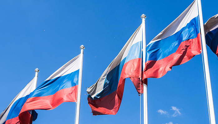 Flags of Russian Federation. Waving flags against blue sky
