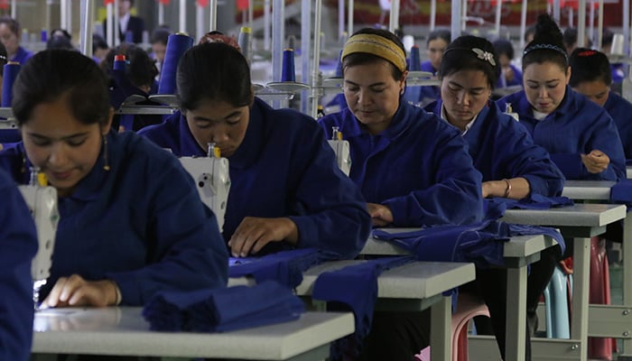 HOTAN, CHINA - APRIL 27 2019. Uigur women work in a cloth factory in Hotan county, Xinjiang province, China.