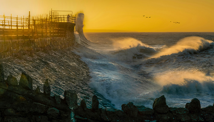 Waves start to increase as Storm Eunice gathers momentum around Porthcawl lighthouse in South Wales UK