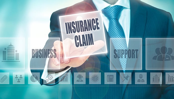 A businessman pressing an Insurance Claim button on a transparent screen.
