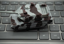 Computer keyboard with tanks on it. An allusion to cyber warfare.concept of cyber attacks.