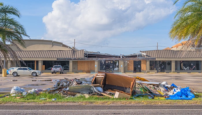 HARAHAN, LA, USA -NOVEMBER 21, 2021: Debris pile and roof damage at a strip mall in the aftermath of Hurricane Ida