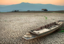 The wood boat on cracked earth, metaphoric for climate change and global warming.