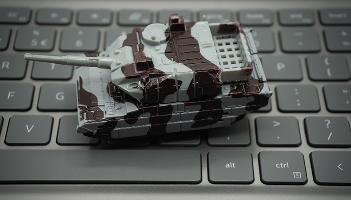Computer keyboard with tanks on it. An allusion to cyber warfare.concept of cyber attacks.
