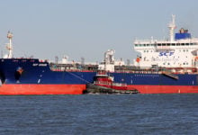 Staten Island, NY, USA - March 4, 2020: Oil Products Tanker SCF USSURI entering Kill Van Kull strait from the East, tugboat KIMBERLY TURECAMO by her side