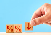 Percentage Down concept. man puts a wooden block with a down arrow next to blocks with percent symbols