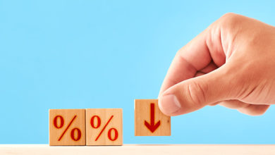 Percentage Down concept. man puts a wooden block with a down arrow next to blocks with percent symbols