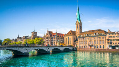 Panoramic view of the historic city center of Zurich with famous Fraumunster Church and munsterbrucke with river Limmat on a sunny day with blue sky, Canton of Zurich, Switzerland