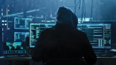 Cyber criminal in front of computers
