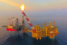 Areal photo of oil and gas platform taken by drone showing gas flare / methane emission