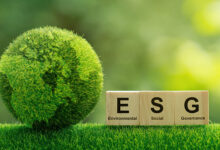 concept image of globe made of grass next to wooden blocks spelling out ESG