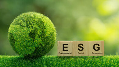concept image of globe made of grass next to wooden blocks spelling out ESG