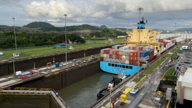 Panama City, Panama - October 22 2022 - Container ship passing through the Miraflores Locks of the Panama Canal. The ship is traveling northbound from the Pacific Ocean to the Atlantic Ocean.