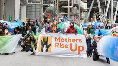 Mothers rise up demonstration, with medium-sized crowd holding banners