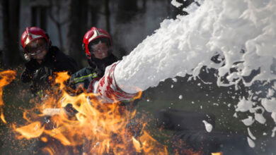 Firefighters extinguishing fire with firefighting product aqueous film forming foam (AFFF)